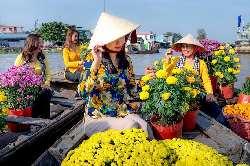 Vietnamese ladies selling flowers on a boat in a river